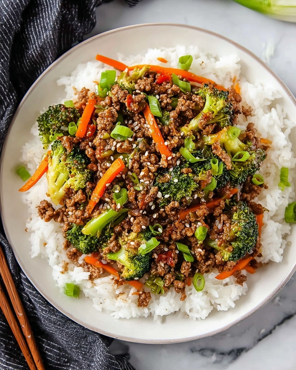A round white plate holds a bed of fluffy white rice as the base layer, topped with a colorful stir-fry mix. The stir-fry consists of brown ground meat, bright green broccoli florets, and thin, bright orange carrot sticks scattered evenly over the meat. Small pieces of green onions are sprinkled on top, along with a few white sesame seeds, adding texture and color contrast. The dish looks fresh and savory with a glossy sauce coating the meat and vegetables. The plate rests on a white marbled surface, with a dark cloth and chopsticks partially visible nearby. Photo taken with an iphone --ar 4:5 --v 7