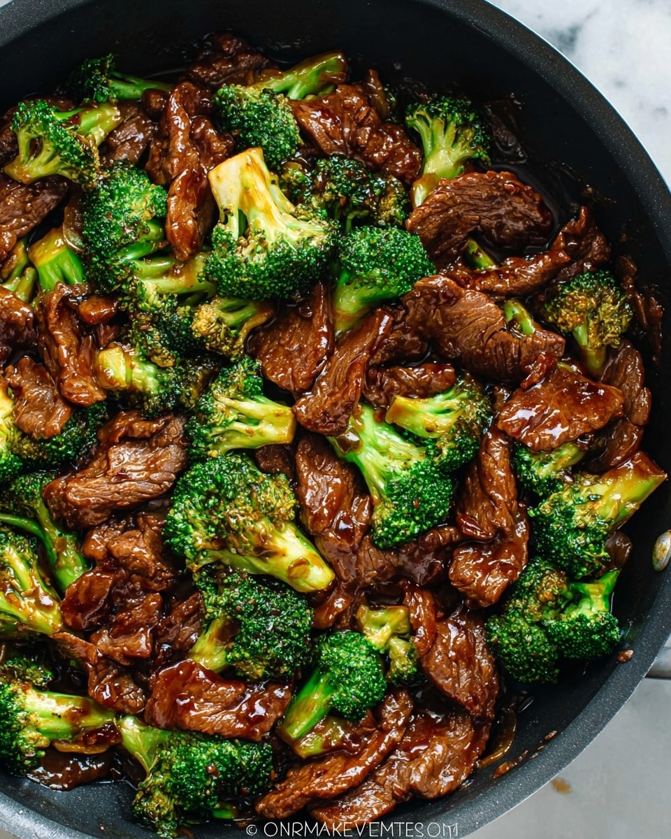 A close-up of a black pan filled with a stir-fry dish showing two main layers: tender pieces of dark brown cooked beef spread evenly throughout, with bright green broccoli florets placed among the beef, all coated in a glossy, rich brown sauce that gives a shiny texture to the ingredients. The beef looks soft and slightly curled at the edges, while the broccoli has a fresh, slightly crisp look with detailed florets. The pan sits on a white marbled surface. Photo taken with an iphone --ar 4:5 --v 7