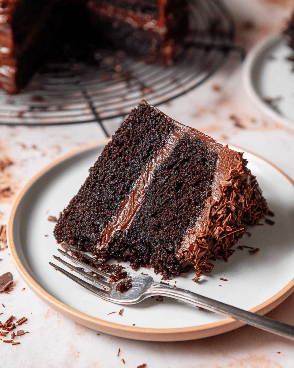 A white plate holds a slice of two-layer dark chocolate cake with a creamy, glossy chocolate frosting layer in the middle and on top, with some chocolate shavings on the right side. The texture of the cake looks moist and soft, and a silver fork rests diagonally on the plate with its prongs touching the cake. The background is a white marbled texture with scattered chocolate crumbs and shavings around the plate, and there is a cooling rack with more pieces of chocolate cake visible in the upper part of the image. photo taken with an iphone --ar 4:5 --v 7