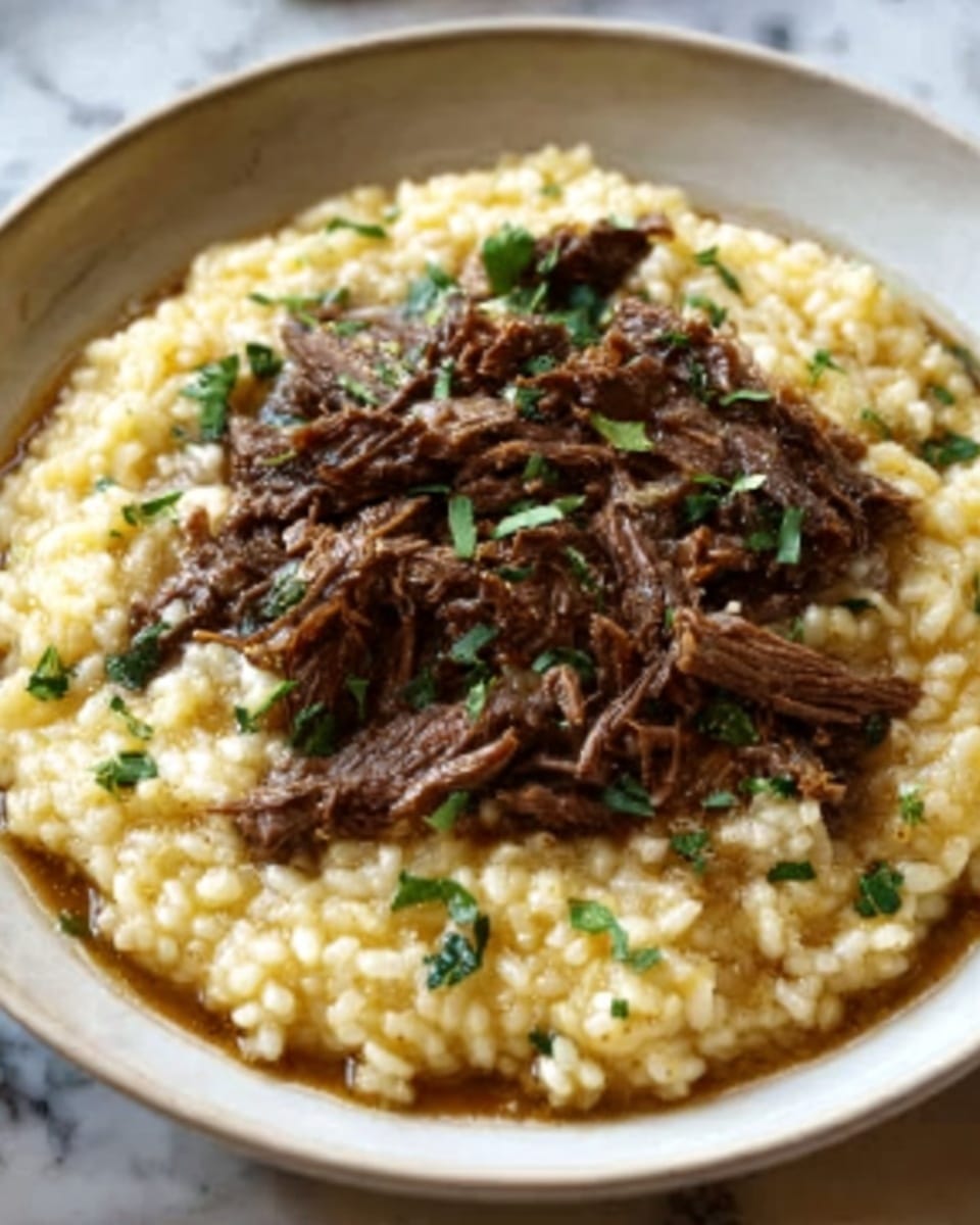 A white shallow bowl filled with a creamy yellow risotto, topped with shredded pieces of dark brown beef scattered evenly across the surface, and sprinkled with small green herb leaves for garnish. The creamy risotto has a soft, slightly glossy texture, while the beef appears tender and slightly moist. The bowl is set on a white marbled surface. Photo taken with an iphone --ar 4:5 --v 7